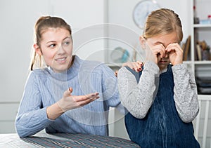 Mother comforts offended little daughter at home