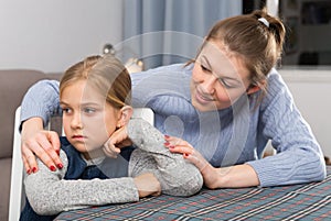 Mother comforts offended little daughter at home