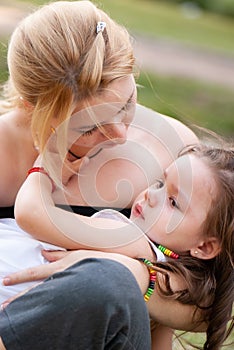 Mother consoles little crying girl in the park