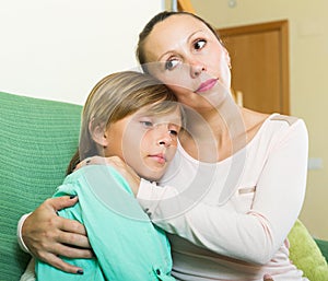 Mother consoling crying teenage son at home