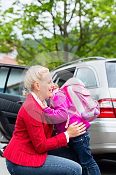 Mother consoling daughter on first day at school