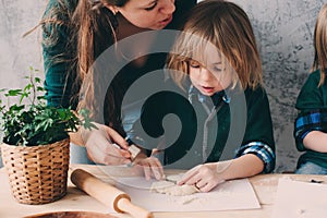 Mother cooking with kids in kitchen. Toddler siblings baking together and playing with pastry at home