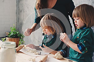 Mother cooking with kids in kitchen. Toddler siblings baking together and playing with pastry at home