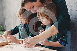 Mother cooking with kids in kitchen. Toddler siblings baking together and playing with pastry at home