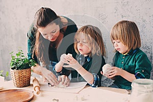 Mother cooking with kids in kitchen. Toddler siblings baking together and playing with pastry at home