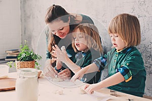 Mother cooking with kids in kitchen. Toddler siblings baking together and playing with pastry at home