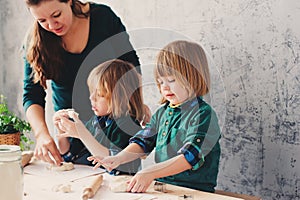 Mother cooking with kids in kitchen. Toddler siblings baking together and playing with pastry at home