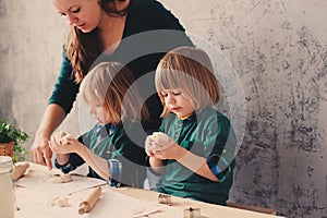 Mother cooking with kids in kitchen. Toddler siblings baking together and playing with pastry at home