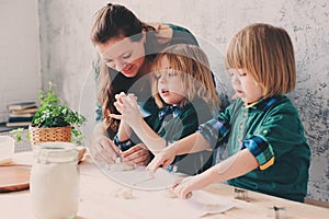 Mother cooking with kids in kitchen. Toddler siblings baking together and playing with pastry at home