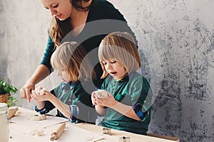 Mother cooking with kids in kitchen. Toddler siblings baking together and playing with pastry at home