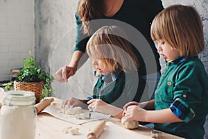 Mother cooking with kids in kitchen. Toddler siblings baking together and playing with pastry at home