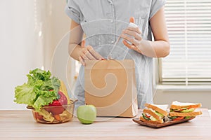 Mother cooking school lunch box set, Preparing healthy snacks - cheese sandwich, fruits and vegetable in paper bag