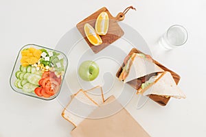 Mother cooking school lunch box set, Preparing healthy snacks - cheese sandwich, fruits and vegetable in paper bag