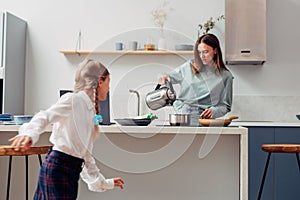 Mother cooks food at home in the kitchen