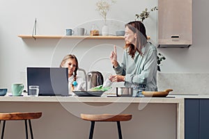 Mother cooks food at home in the kitchen