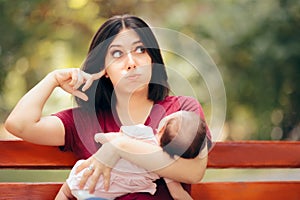 Mother Covering Her Ears While Baby Cries Loudly