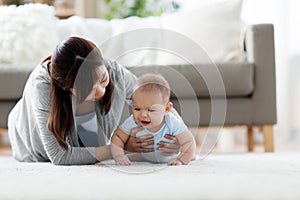 Mother with crying little baby boy at home