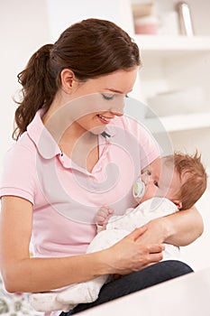 Mother Cuddling Baby Boy At Home