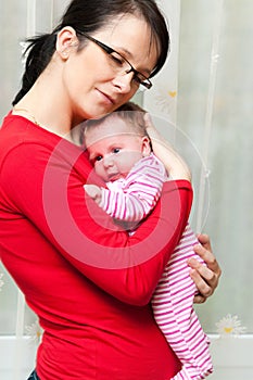 Mother cuddling baby girl photo