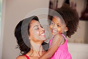 Mother Cuddling Daughter At Home