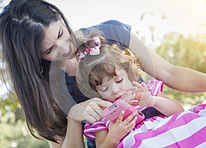 Mother and Cute Baby Daughter Playing with Cell Phone