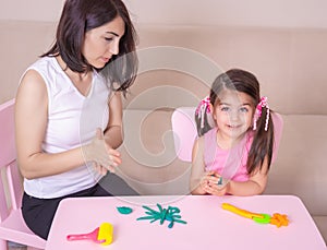 Mother and Cute girl playing together with playdough