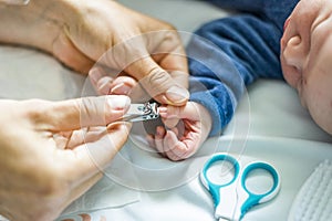 Mother cuts fingernails of her newborn baby boy