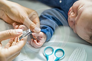 Mother cuts fingernails of her newborn baby boy