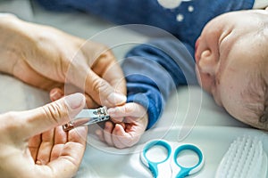 Mother cuts fingernails of her newborn baby boy