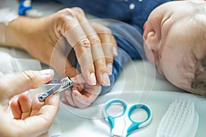 Mother cuts fingernails of her newborn baby boy