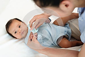 mother cutting baby's hand fingernails with nail scissors