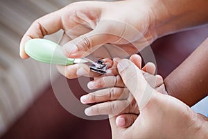 Mother cutting fingernails for her baby