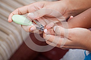 Mother cutting fingernails for her baby