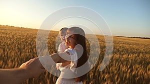 Mother dad and daughter play holding hands. teamwork mother and child walking in the field, holding her beloved man`s