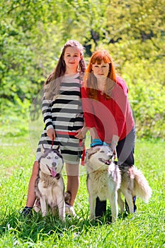 Mother and daughter along with two dogs in park on