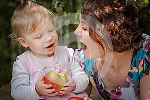 Mother and daughter with apple in the hand