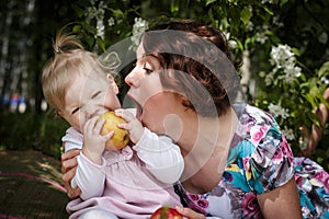 Mother and daughter with apple in the hand