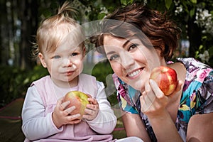 Mother and daughter with apple in the hand