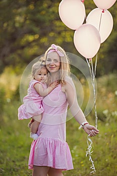 mother with daughter and balloons in hands