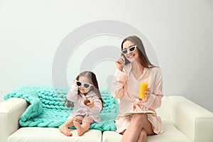 Mother and daughter in bathrobes on sofa