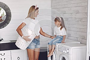 Mother and daughter in a bathroom near wash mashine