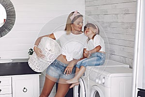 Mother and daughter in a bathroom near wash mashine