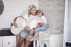 Mother and daughter in a bathroom near wash mashine