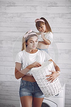 Mother and daughter in a bathroom near wash mashine