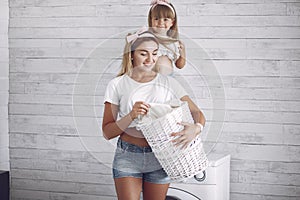 Mother and daughter in a bathroom near wash mashine