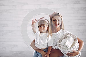 Mother and daughter in a bathroom near wash mashine