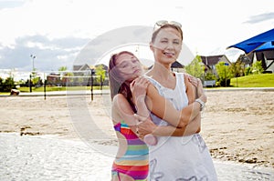 Mother and daughter at the beach embracing