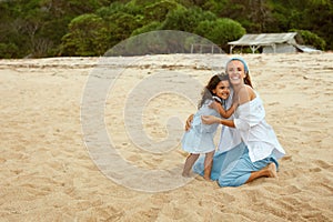 Mother And Daughter On Beach. Young Woman In Fashion Dress And Little Girl Enjoying Summer Weekend. Family Vacation.