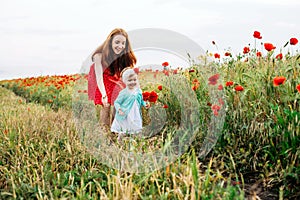 Mother and daughter in beautiful poppy field