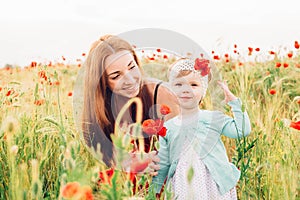 Mother and daughter in beautiful poppy field